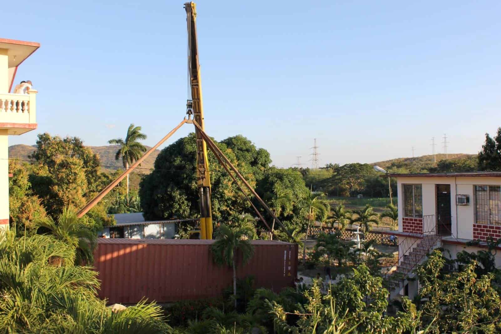 A Shipping Container Carefully Lowered on a Property through a Crane